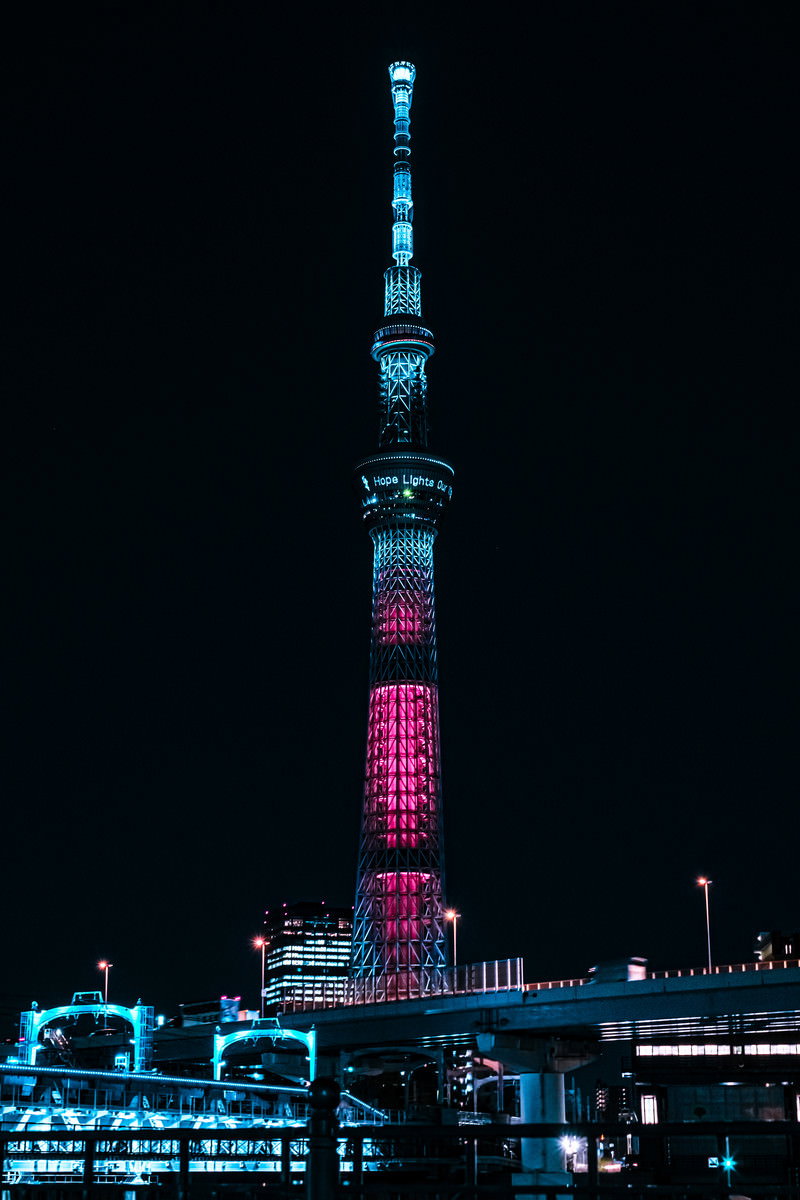 暗闇の中で青とピンクの光にライトアップされた東京スカイツリー