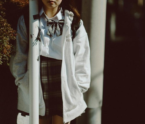 パーカーを羽織った制服姿の女子高生