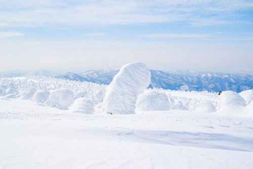 晴天に佇む蔵王の樹氷とスノーモンスター、青い山々