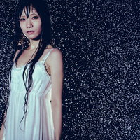 雨に濡れたワンピース姿の女性、水滴が飛び散るの写真