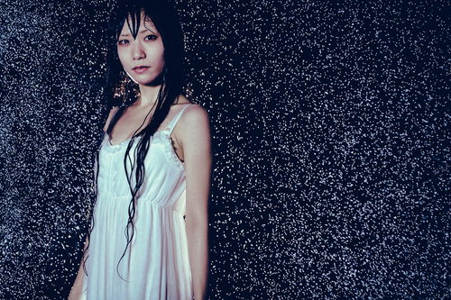 雨に濡れたワンピース姿の女性、水滴が飛び散る