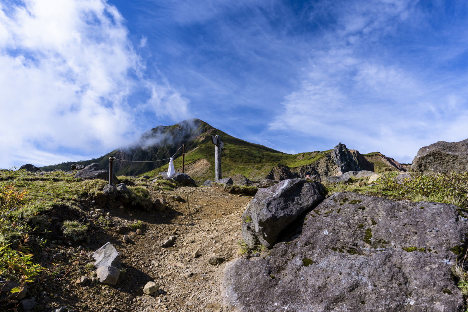 磐梯山山頂付近の岩場の登山道と青空が広がる風景