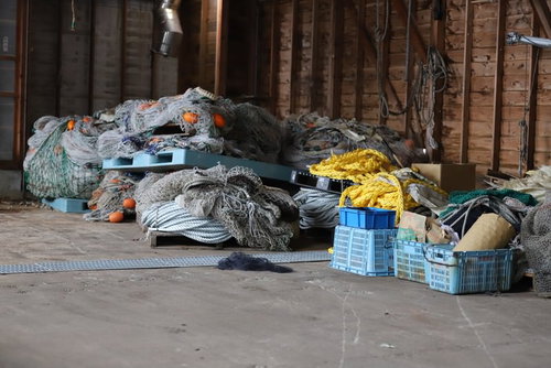 漁港の倉庫に積まれた網とロープ、漁具の保管風景
