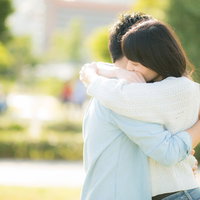 屋外で感動的にハグをするカップルの男女が抱き合う恋愛の写真