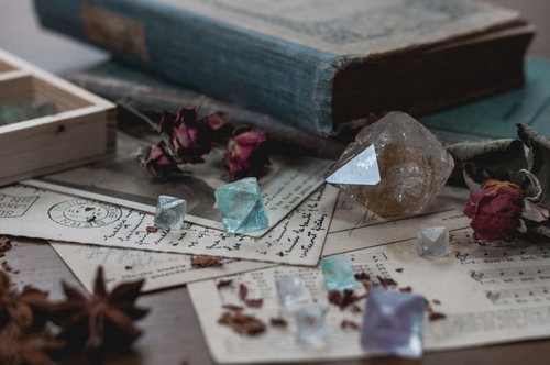 古い洋書の上に置かれたクリスタルと天然石