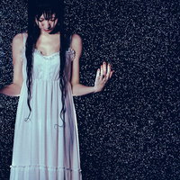 水を集めはじめた豪雨でびしょ濡れになった女性の写真