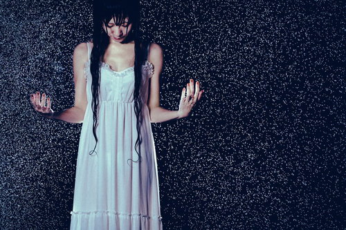 水を集めはじめた豪雨でびしょ濡れになった女性