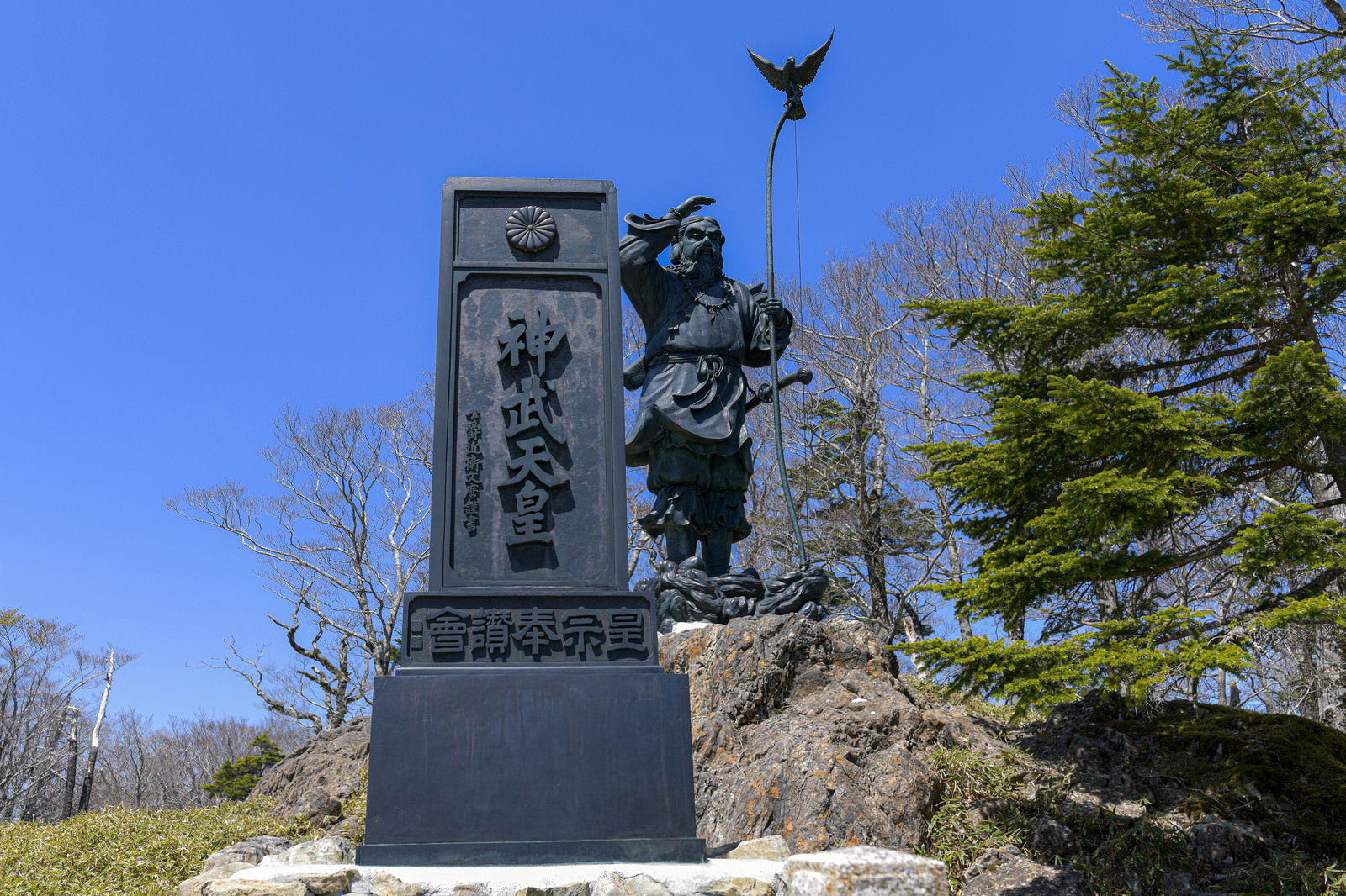 青空の下、大台ヶ原山頂に建つ神武天皇の銅像と記念碑