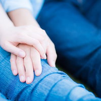 デニムを着た男女が手を重ねる恋人カップルのペアルックの写真