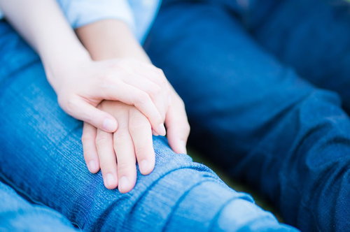 デニムを着た男女が手を重ねる恋人カップルのペアルック