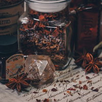 怪しげなハーブと古い洋書に置かれた小瓶のアンティークの写真