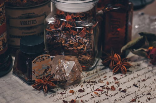 怪しげなハーブと古い洋書に置かれた小瓶のアンティーク