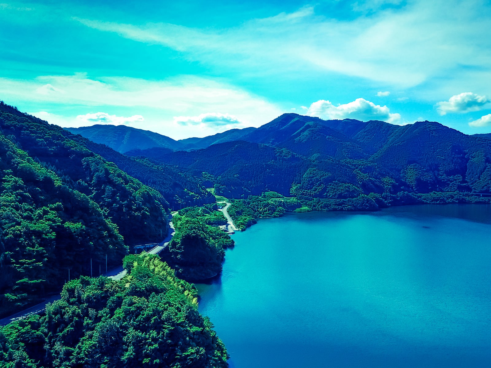 苫田ダムによって造られた奥津湖を空撮した風景。エメラルドグリーンの湖面と緑の山々が美しい