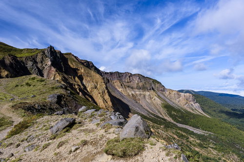 雲が飛び交う磐梯山の険しい稜線と活火山の岩肌