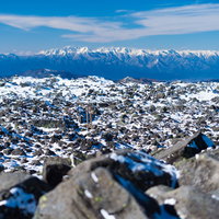 蓼科山山頂の岩稜に立つ赤い鳥居と雪山の絶景の写真