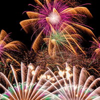 一斉にはじける打上げ花火、色とりどりのスパークが夜空に光跡を描くの写真