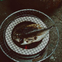 七輪の網で焼くアジの開きの写真