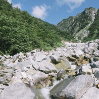 秩父沢周辺から笠ヶ岳の稜線を見上げる岩場の風景の写真