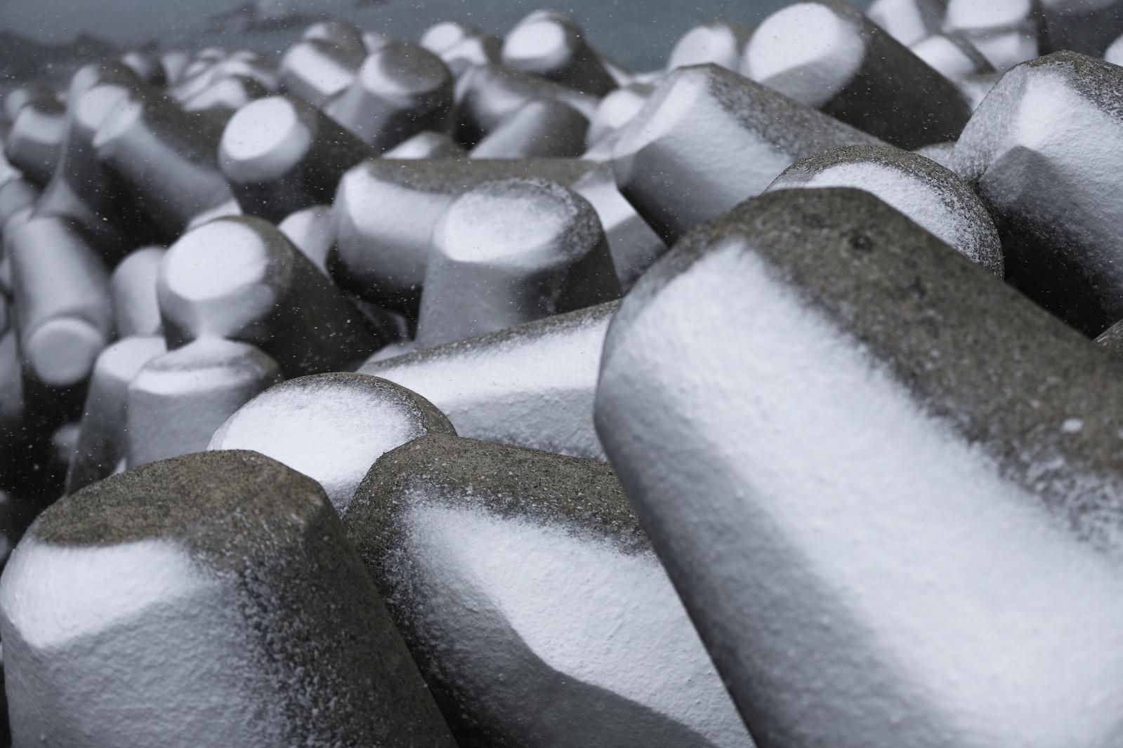 Regularly arranged snow-covered breakwater blocks (tetrapods)