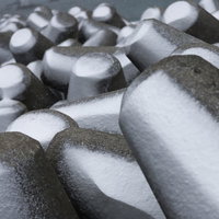雪化粧した消波ブロック（テトラポッド）が規則的に配置された海岸の写真