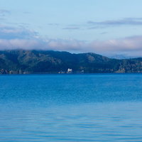 朝霧の田沢湖と対岸の山並みの写真