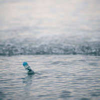 波打ち際に立つラムネ瓶の夏の思い出の写真