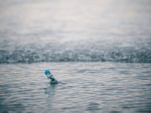 波打ち際に立つラムネ瓶の夏の思い出