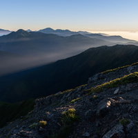 朝日に浮かぶ南アルプス北部の山脈と稜線の雄大な風景の写真