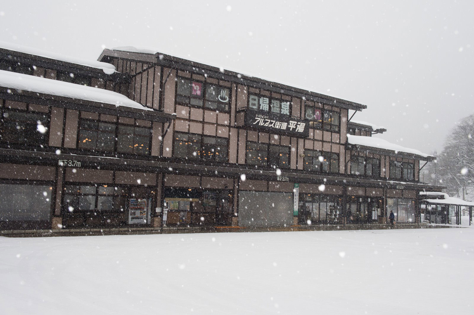 雪に覆われた平湯バスターミナルの木造建物と白い雪景色