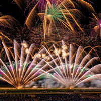 地上から打ち上がる大花火と光跡の夜景の写真