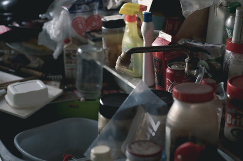 物で溢れ散らかった台所のシンク周りと調理器具