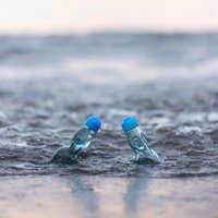 ラムネ瓶と海辺の波打ち際での青春。夏の思い出の写真