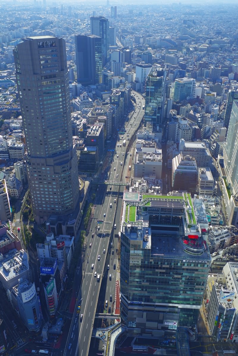 渋谷周辺の高層ビル群と道路が交差する都市景観を上空から撮影