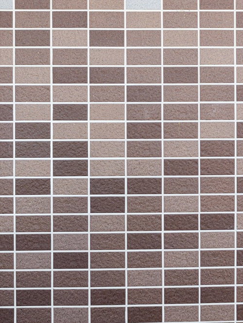 ベージュとブラウンの真新しいタイル壁と白い目地のテクスチャー