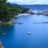 浄土ヶ浜の青い海に白い岩礁とボートの写真