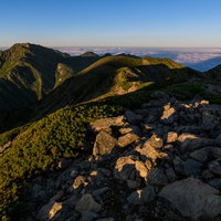 朝日に焼ける南アルプス赤石岳の縦走路と山稜線の写真