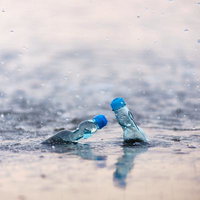 青春のラムネと海岸の波打ち際、透明な瓶に映る夏の思い出の写真