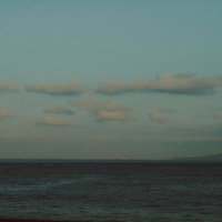 穏やかな海と浮かぶ白い雲が映える水平線の風景の写真