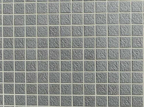 黒いブツブツのある正方形タイル壁のテクスチャ