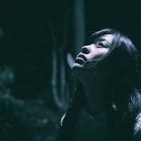 月の明かりが私を照らす暗闇の中で絶望する女性のホラーの写真