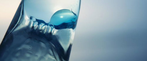 ラムネ瓶から飛び出すガラス玉と水滴の瞬間