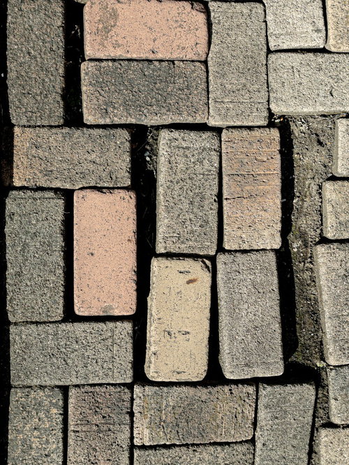 地面に不規則に並べたレンガブロックと建材