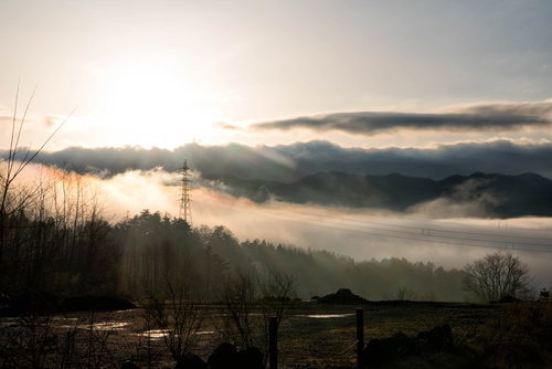 雲海に浮かぶ山間の鉄塔と送電線の絶景 朝焼けの田舎風景
