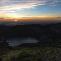 夜明け前の蔵王山御釜、朝焼けに染まる火口湖の写真