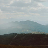 くもり空が覆う山々の遠景の写真
