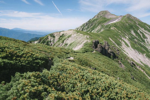稜線から眺める笠ヶ岳の登山道と連なる山々の風景