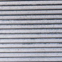 グレーの金属製シャッターに浮き出る横縞模様の写真