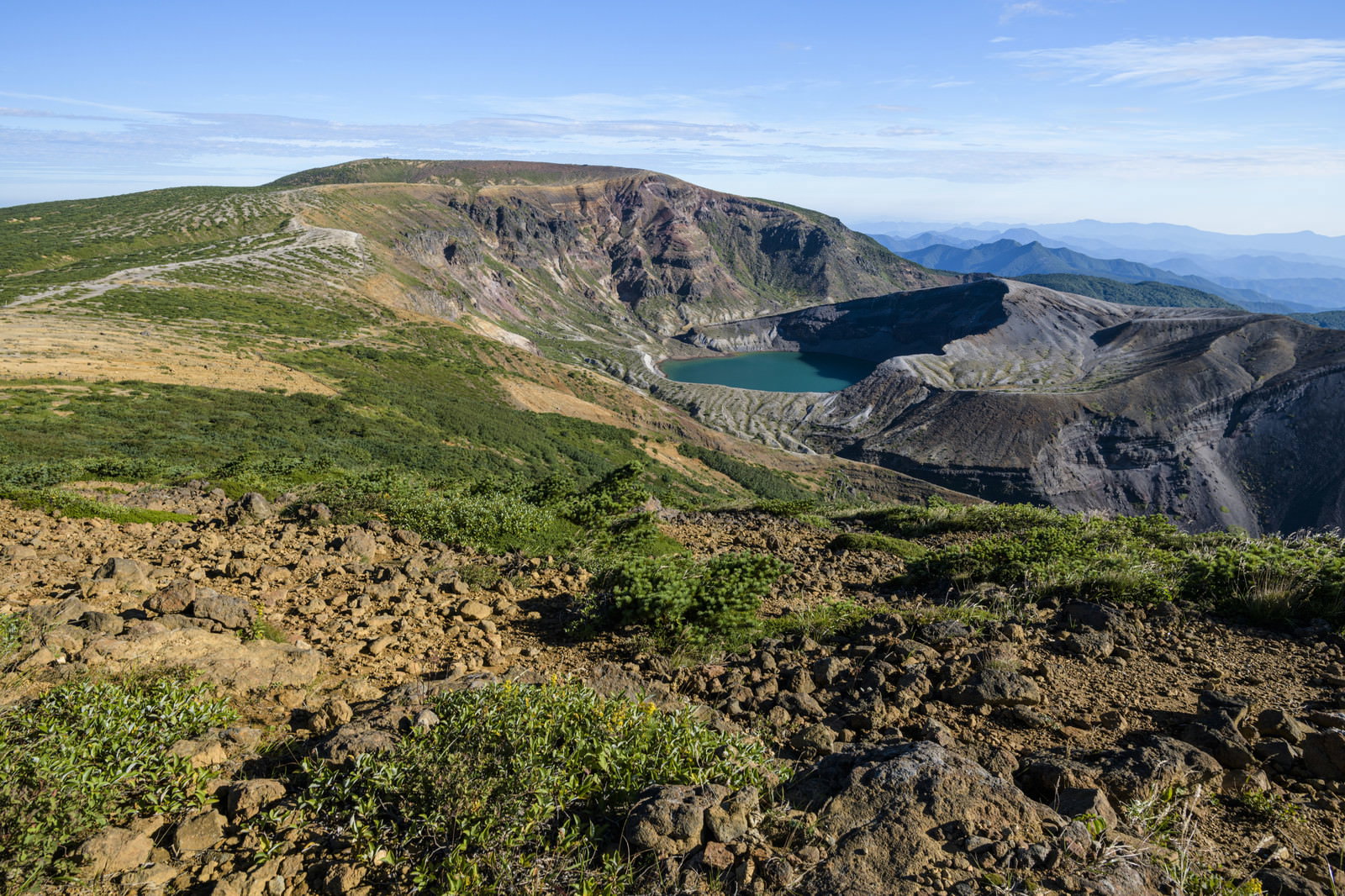 蔵王山山頂のカルデラ内にあるエメラルドグリーンの火口湖御釜と周囲の山肌