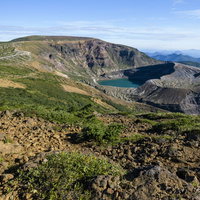 晴天に輝く蔵王山山頂の御釜、エメラルドグリーンの火口湖の写真