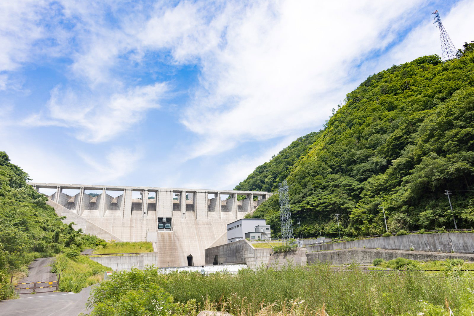 緑の山々に囲まれた苫田ダムと青空